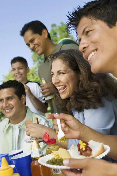 Familj och vänner vid picknickbord — Stockfoto