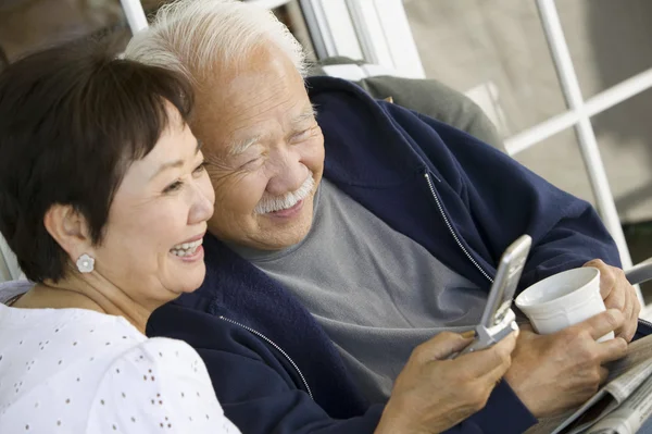 Casal sênior usando telefone celular — Fotografia de Stock