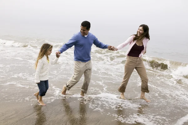 Família descalça andando na praia — Fotografia de Stock