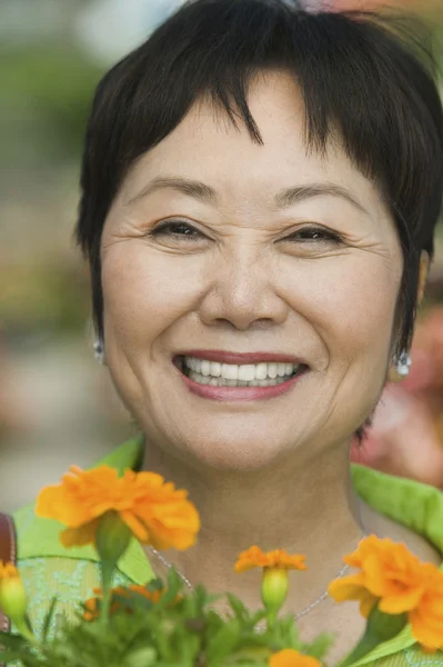 Vrouw bedrijf bloemen — Stockfoto