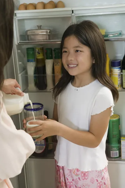 Mutter gießt Milch für Tochter — Stockfoto