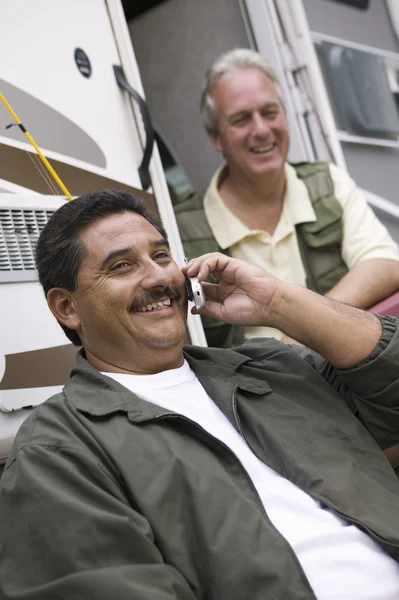 Männer sitzen neben Wohnwagen — Stockfoto