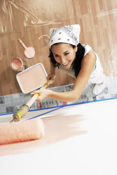 Vrouw toepassing van verf op een muur — Stockfoto