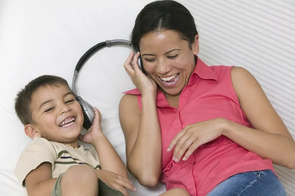 Mãe e filho compartilhando fone de ouvido — Fotografia de Stock