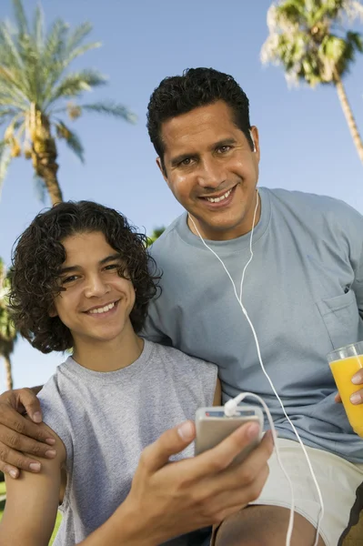 Far och son lyssnar på mp3-spelare — Stockfoto