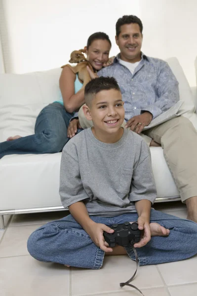 Родители смотрят, как сын играет в видеоигры — стоковое фото