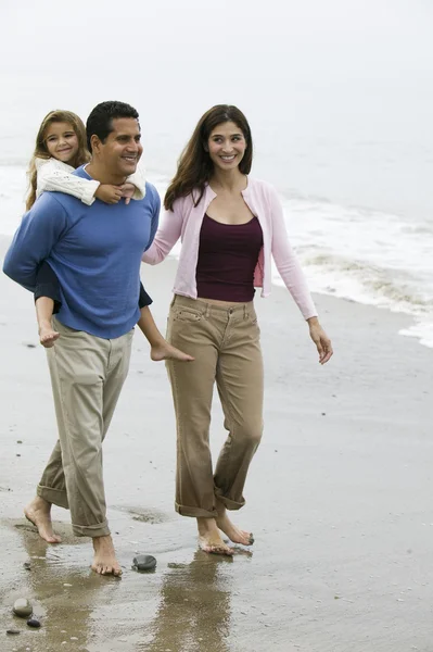 Familia caminando en la playa — Foto de Stock