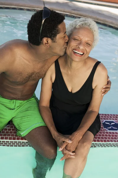 Man kissing mother at swimming pool — Stock Photo, Image