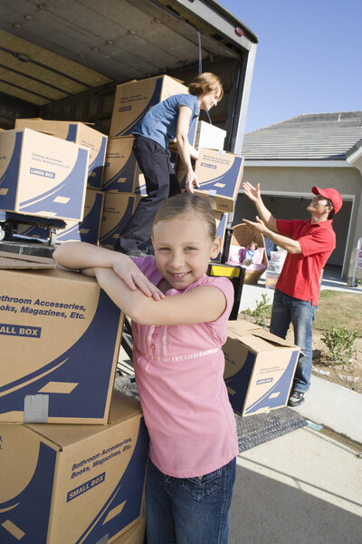 Girl by truck of cardboard boxes