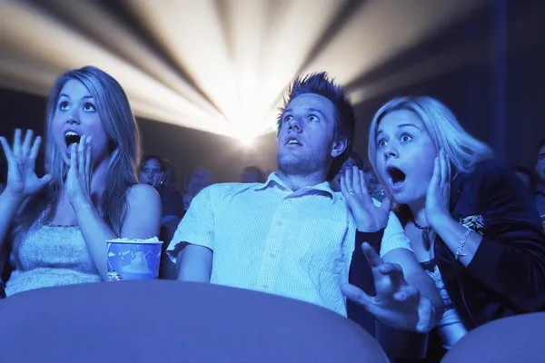 Ludzie oglądania filmu grozy w teatrze — Zdjęcie stockowe