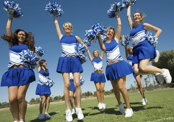 Cheerleaders stiger pom-poms — Stockfoto