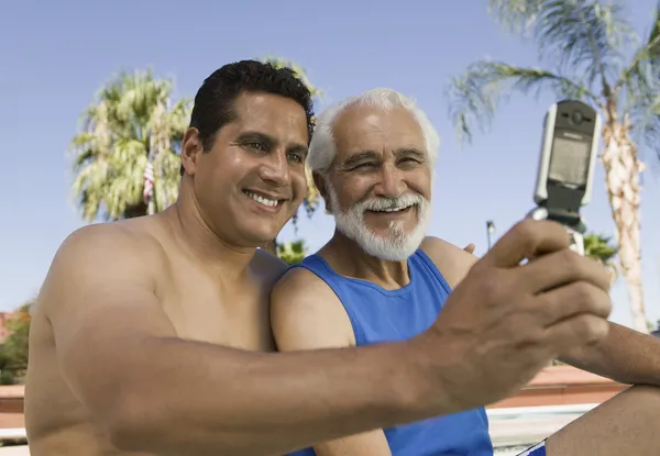 Старший отец и сын фотографируют на мобильный телефон — стоковое фото