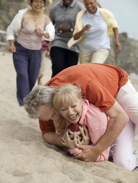 Man tackling woman with football — Stock Photo, Image