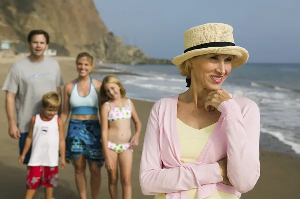 Grootmoeder op strand met familie — Stockfoto