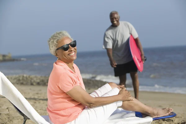 Vrouw zitten op strandstoel — Stockfoto