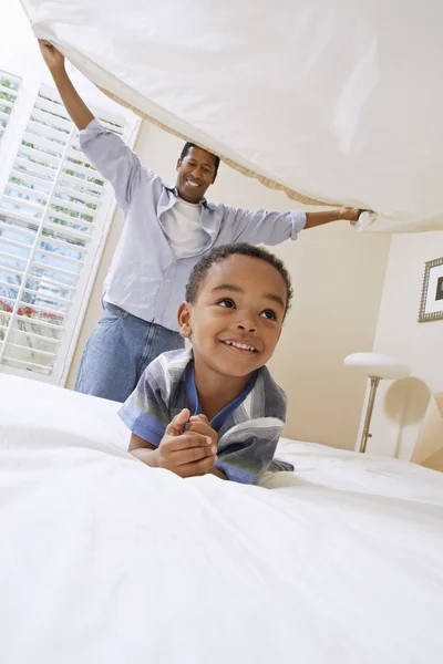 Father holding bedsheet over his son — Stock Photo, Image