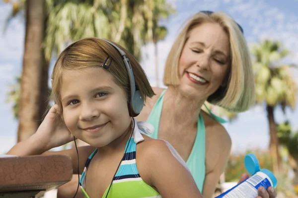 Mormor tillämpa solskyddsmedel på flicka — Stockfoto
