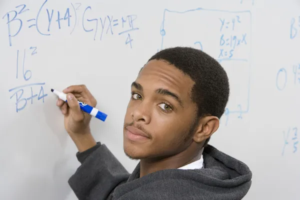 Student writing maths equations — Stock Photo, Image