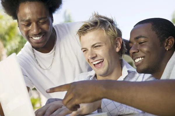 Vrienden lachen kijken naar laptop — Stockfoto