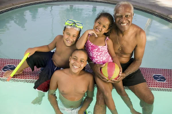 Dědeček s vnoučaty v bazénu — Stock fotografie