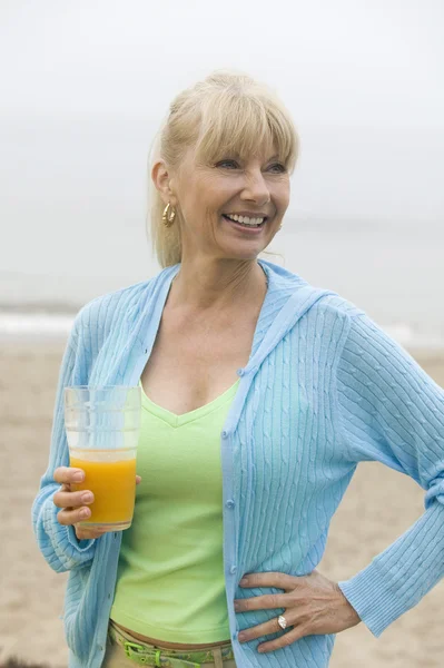 Donna in spiaggia con succo di frutta — Foto Stock