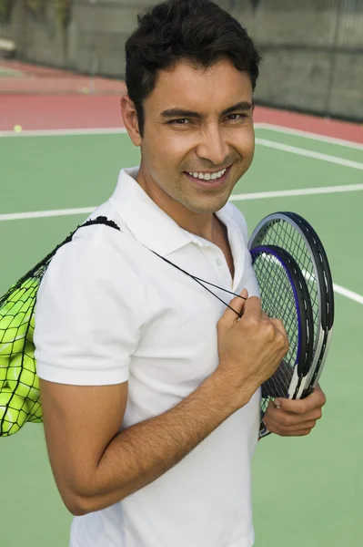 Uomo con racchetta da tennis e palline — Foto Stock