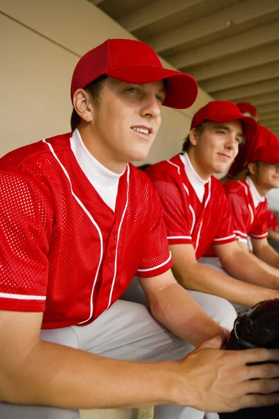 Compañeros de equipo de béisbol sentados en dugout —  Fotos de Stock