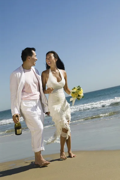 Наречена і наречений гуляють на пляжі — стокове фото