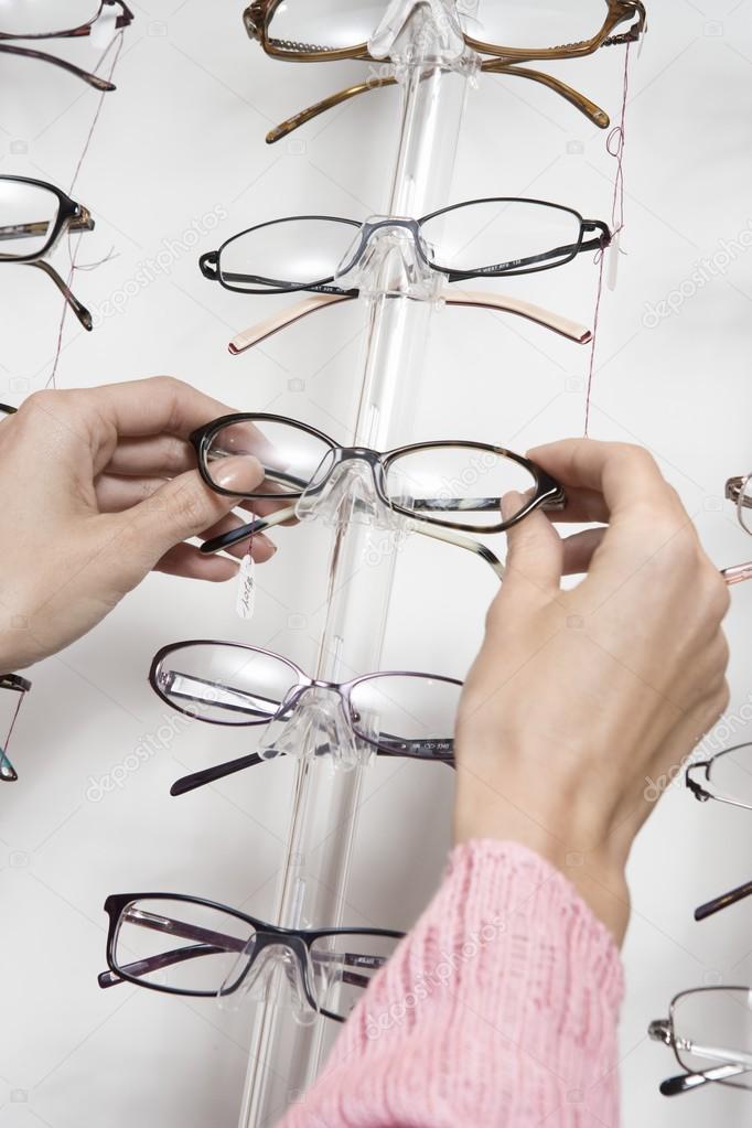 Hands choosing eyeglasses