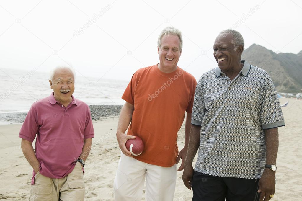 Senior men walking on beach