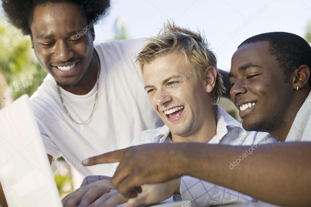 Friends laughing looking at laptop