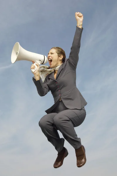 Businesswoman shouting in bullhorn — Stock Photo, Image