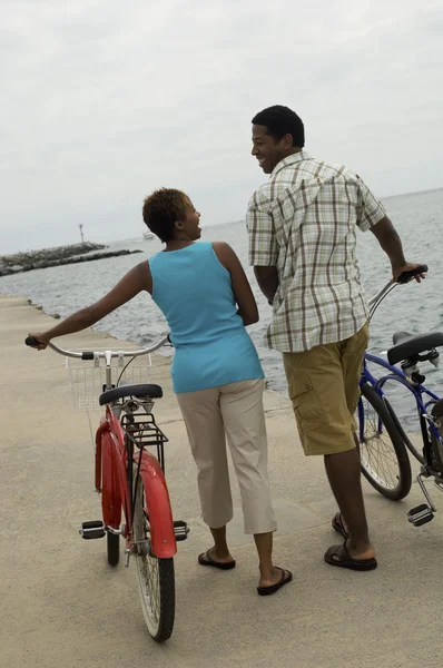 Pareja caminando con bicicletas — Foto de Stock