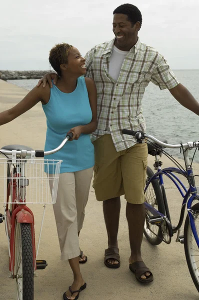 Pareja caminando con bicicletas — Foto de Stock