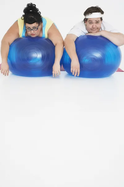 Man and woman lying on Exercise Balls — Stock Photo, Image