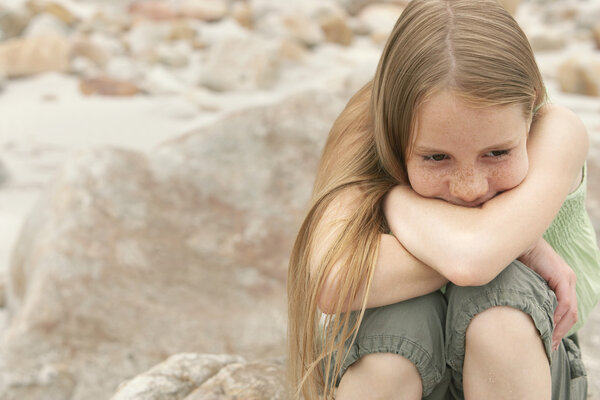 Girl sitting on rock at beach