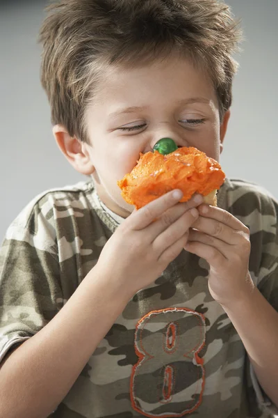 Pojken äta en cupcake — Stockfoto