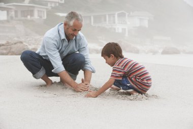 Father and son making sand castle clipart