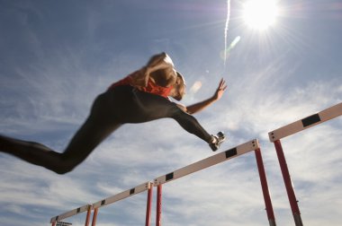 Male athlete jumping hurdle clipart