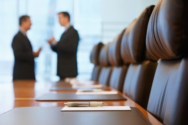 Businessmen talking in conference room clipart