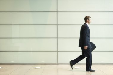 Office koridordan uzun adımlarla işadamı