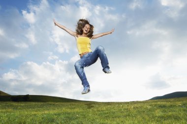 Woman jumping in meadow clipart