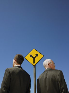 Businessmen standing by  sign clipart