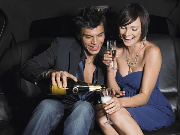 Couple in limousine drinking champagne — Stock Photo, Image