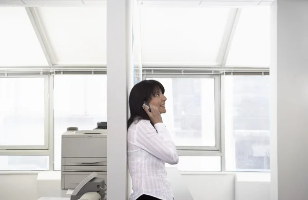 Lavoratrice in ufficio utilizzando il telefono cellulare — Foto Stock