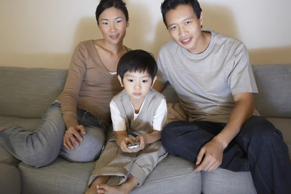 Par med sonen tittar på TV — Stockfoto