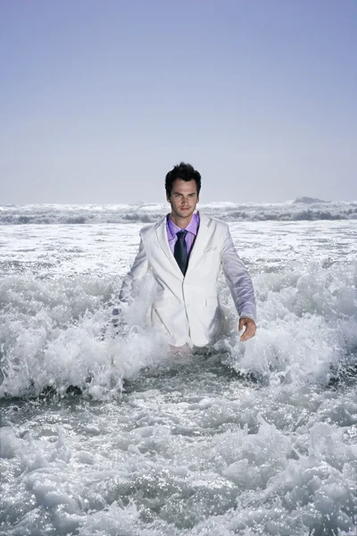 Businessman walking into sea — Stock Photo, Image