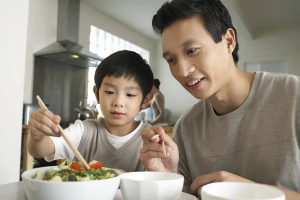 Far och son med ätpinnar — Stockfoto