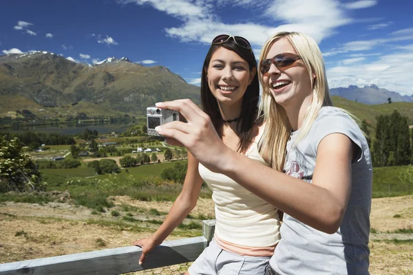 Deux femmes prennent une photo contre une clôture — Photo