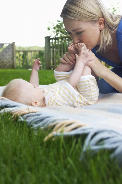 Anne ve bebek çim üzerinde yalan — Stok fotoğraf